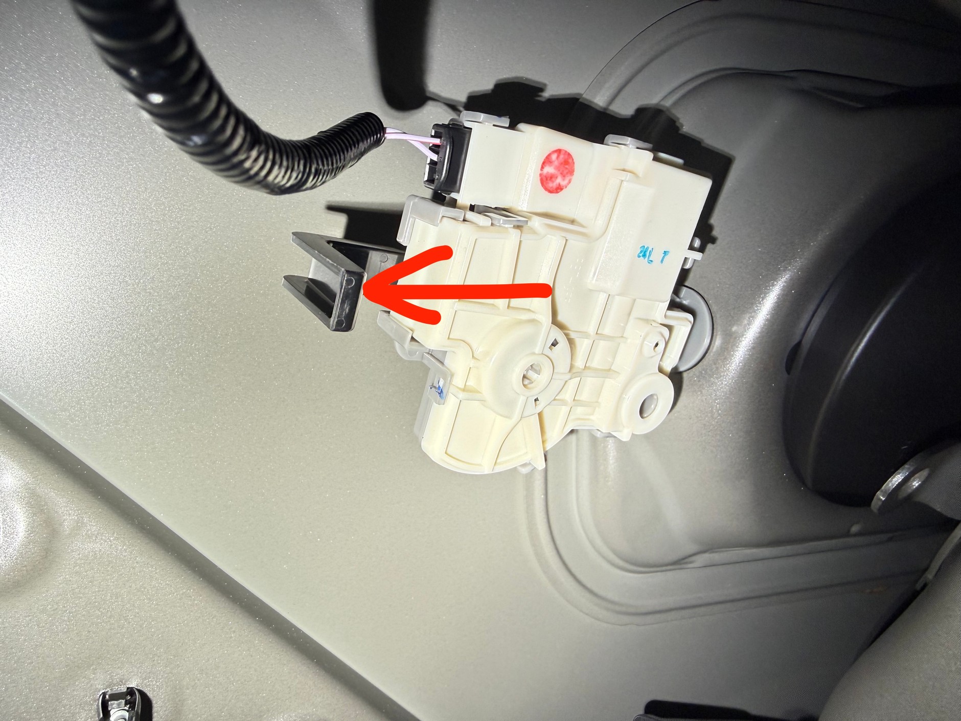 Zaglądamy przez otwór, a tam... w tym przypadku do awaryjnego otwarcia wlewu służy plastikowa dźwigienka na zamku elektrycznym, którą wystarczy pociągnąć