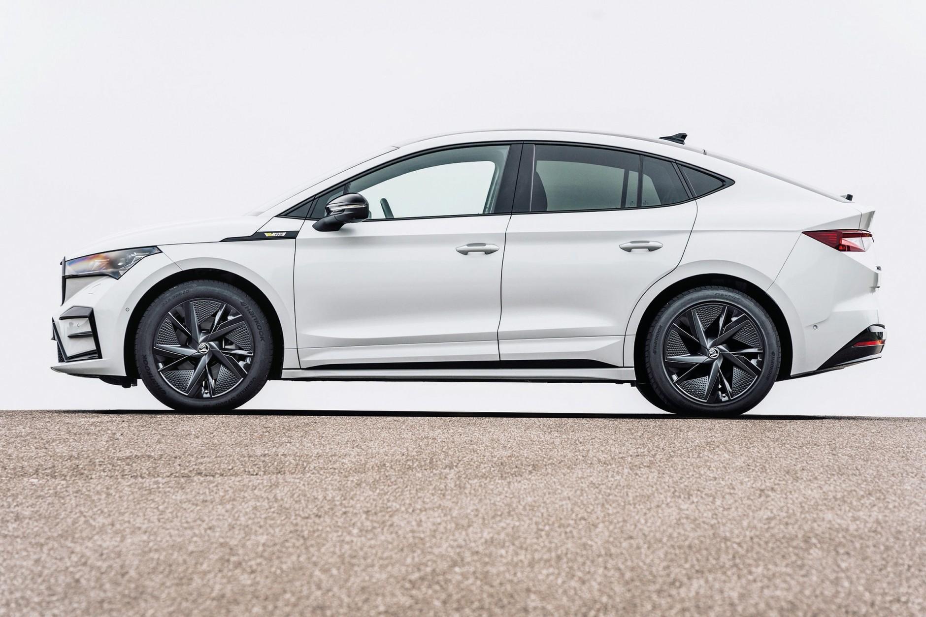Skoda Enyaq Coupe 2022 - styliści zrobili, co tylko mogli, żeby załagodzić linie SUV-a i dodać im wdzięk, ale... Niestety, topografia platform elektrycznych jest bezlitosna i te mniej więcej 10 cm grubości baterii w podłodze "widać" po sylwetce. W efekcie auto wygląda zbyt potężnie, żeby skojarzy je z coupe z czasów klasycznej motoryzacji. No ale z drugiej strony - czy pierwsze BMW X6, protoplasta SUV-ów coupe, było zgrabniejsze?