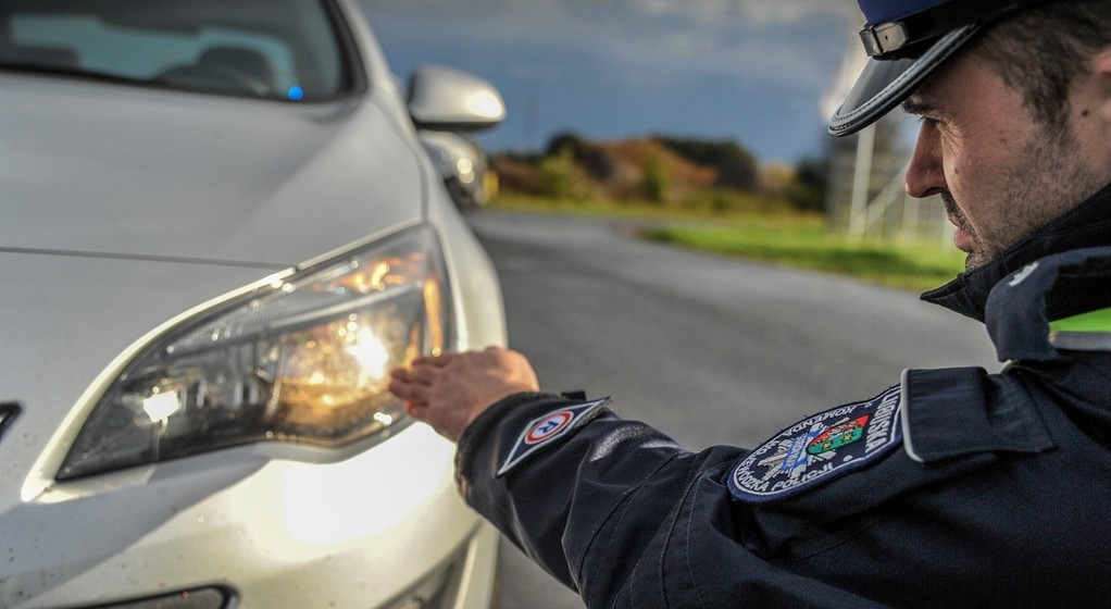 Policjant sprawdza światła podczas kontroli drogowej