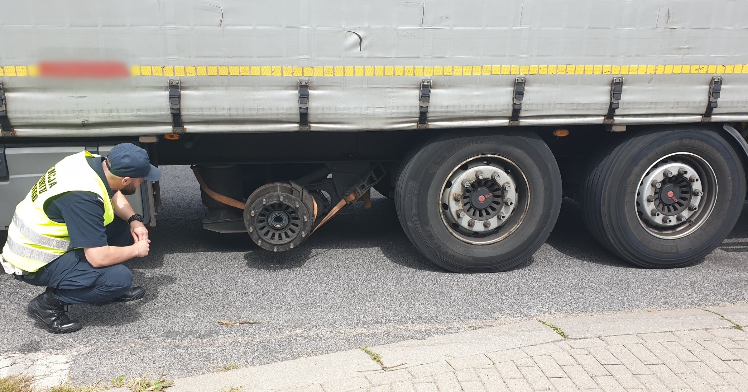 W naczepie brakowało jednego koła, a "pusta" oś została podwieszona na pasie transportowym