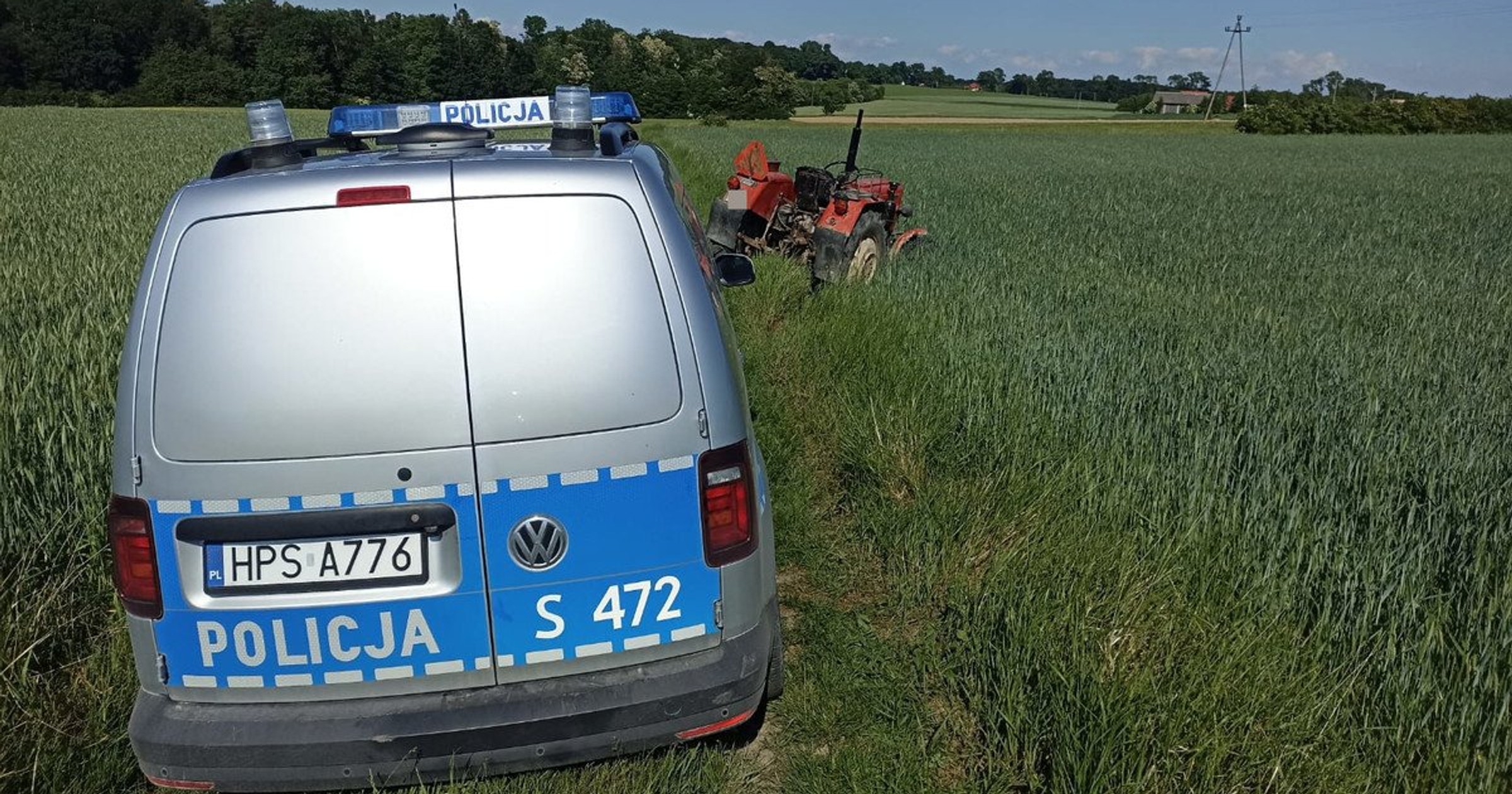 Radiowóz i traktor w polu