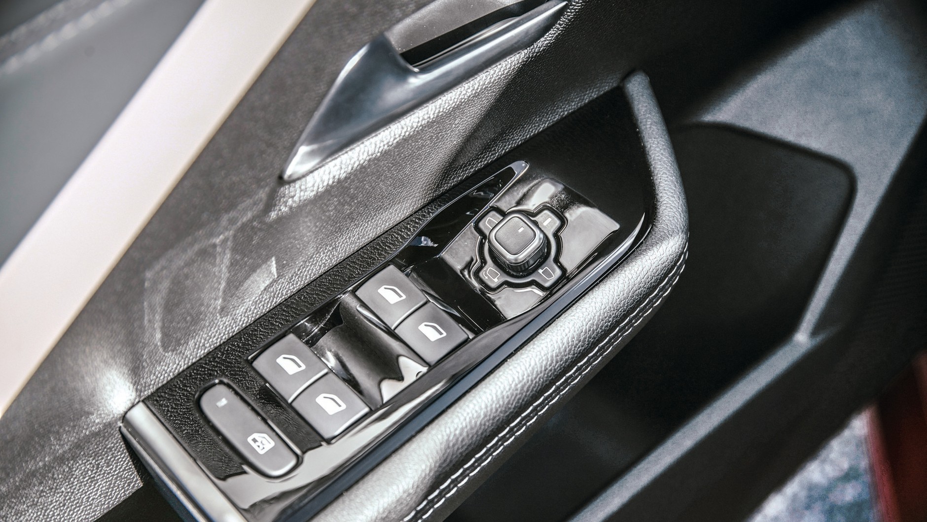 Opel Astra 2022 - wszystko po lewej stronie: sterowanie szybami oraz lusterkami zgrupowano na podłokietniku drzwi kierowcy.