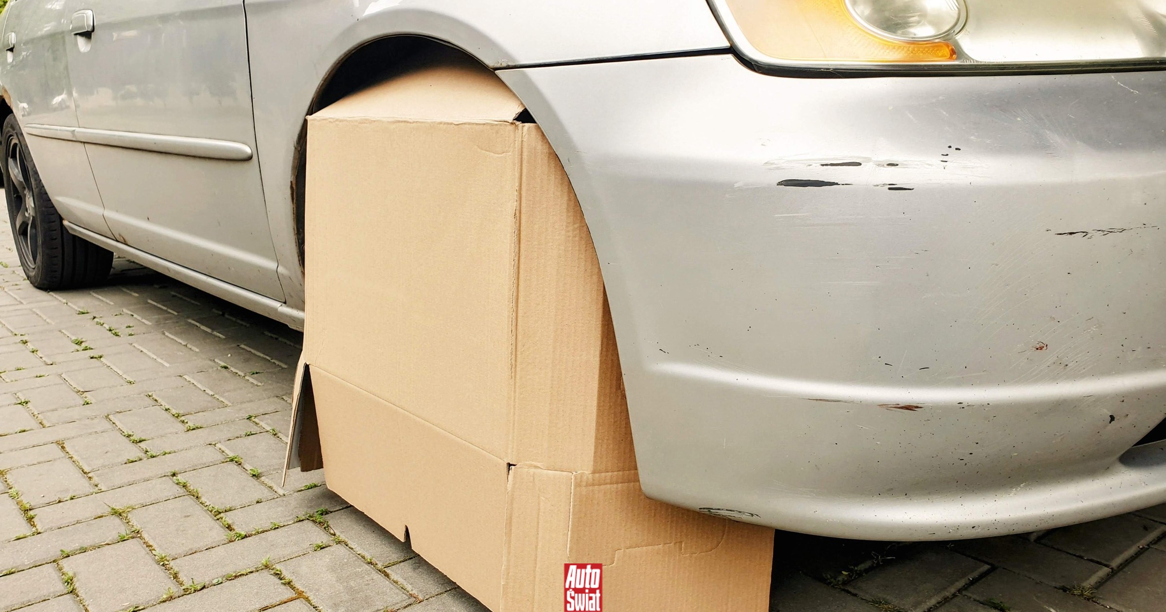 Un'auto parcheggiata in un'area ombreggiata con un rullo di tela per proteggere i reflettori