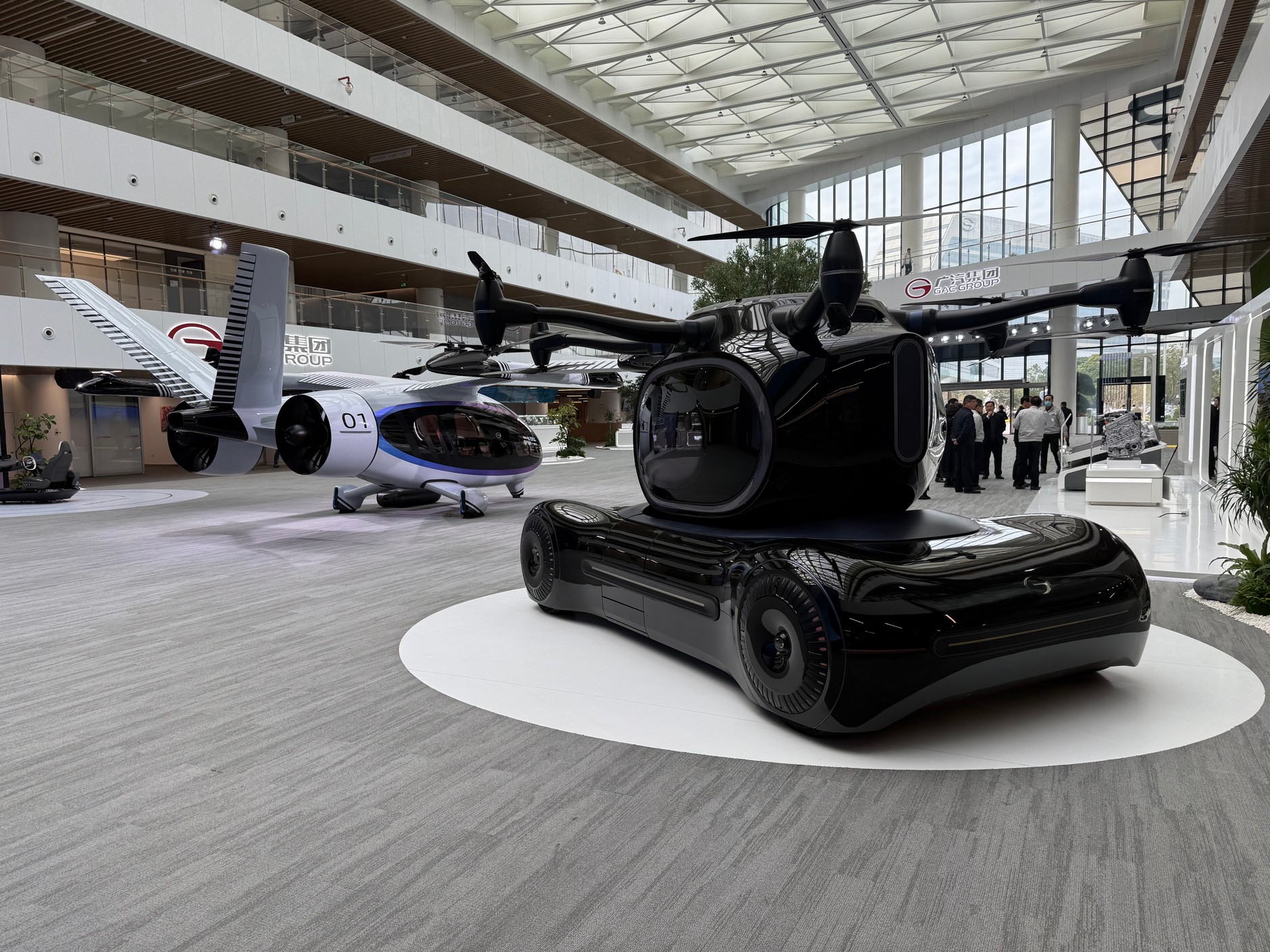 Marzenie o latających samochodach – prototyp (we wczesnej fazie) wystawiony w siedzibie głównej GAC. Guadrocopter ma odłączać się od jeżdżącej podstawy zdolnej do autonomicznej jazdy. Na razie baterie są zbyt ciężkie