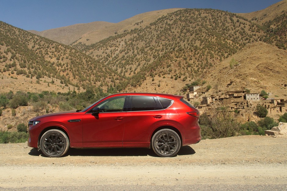 Mazda CX-60 na tle zburzonej górskiej osady