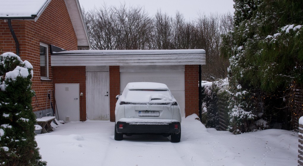 Samochód stojący przed garażem zimą