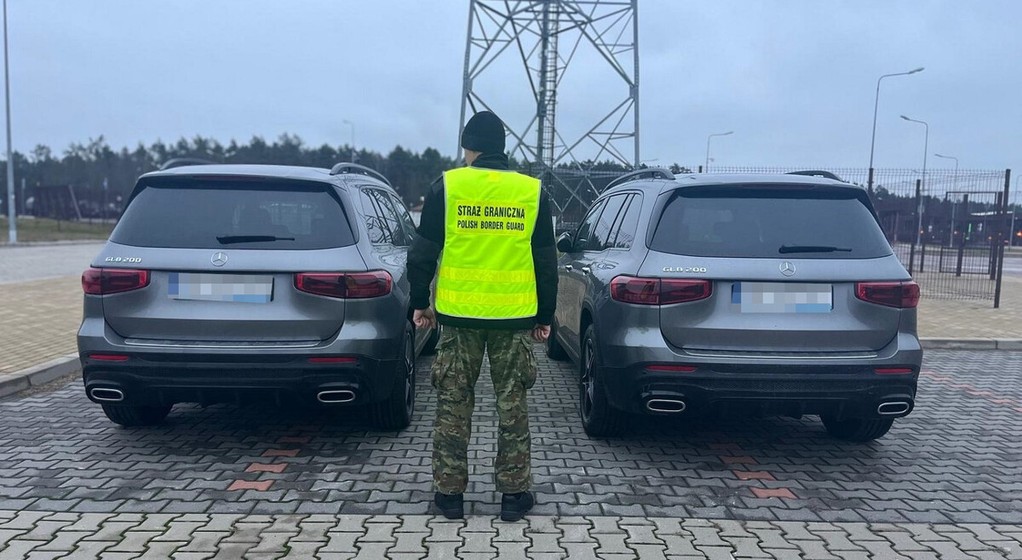 Funkcjonariusz SG stoi przy dwóch Mercedesach