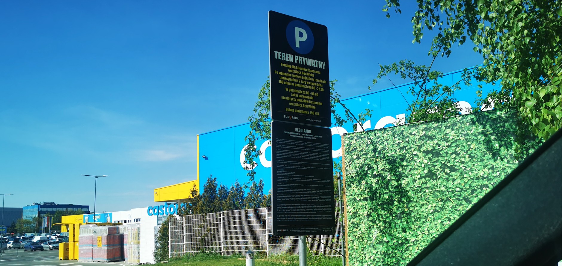 Tabliczka informacyjna i regulamin parkingu. Takie oznakowanie to rodzaj pułapki na kierowców – nieuważni płacą kary umowne