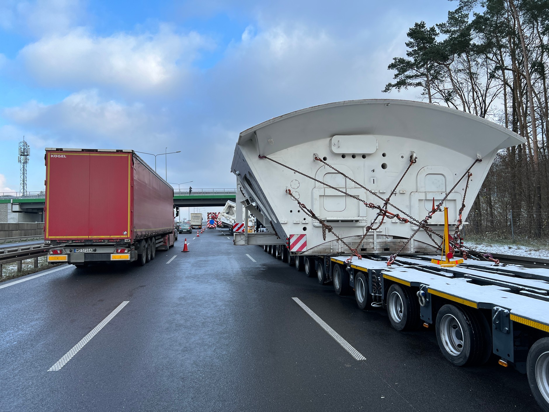 Transport gigantycznej maszyny czeka przed wjazdem do Warszawy na drodze ekspresowej S8 w pobliżu węzła Janki