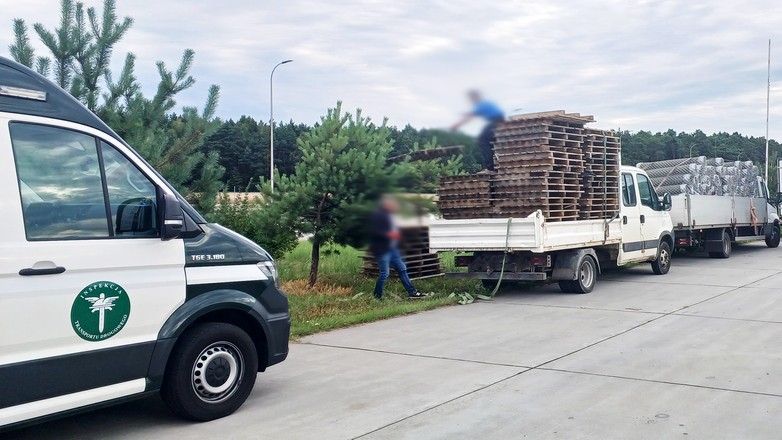 Kierowca rozładowuje puste palety, by móc pojechać dalej