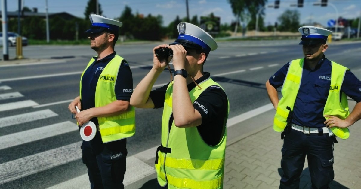 Policjanci korzystają z lornetek do typowania pojazdów do kontroli