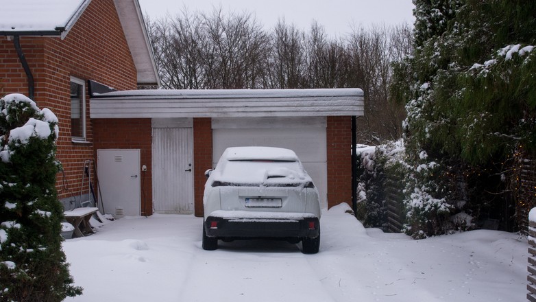 Samochód stojący przed garażem zimą