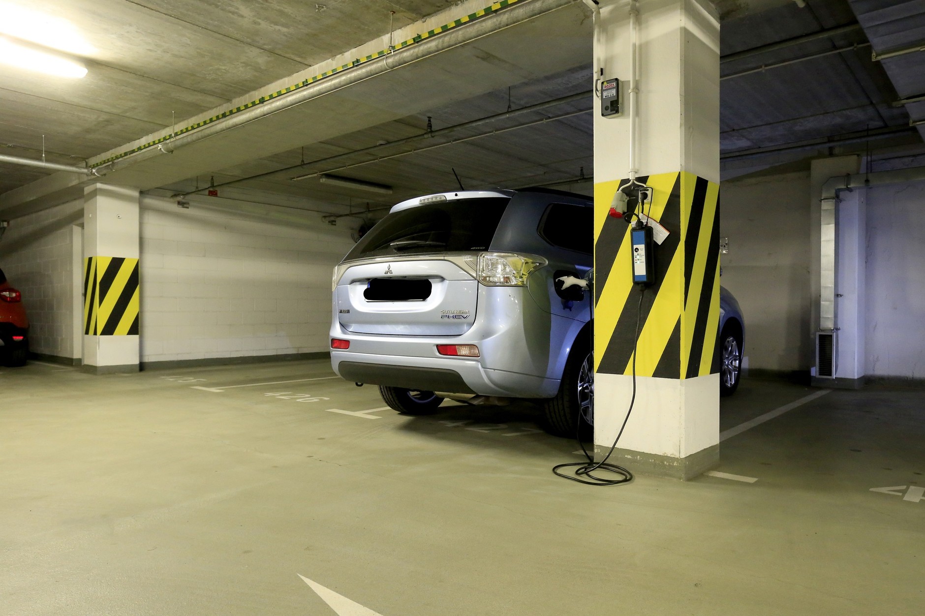 Ładowanie samochodu w garażu bloku mieszkalnego