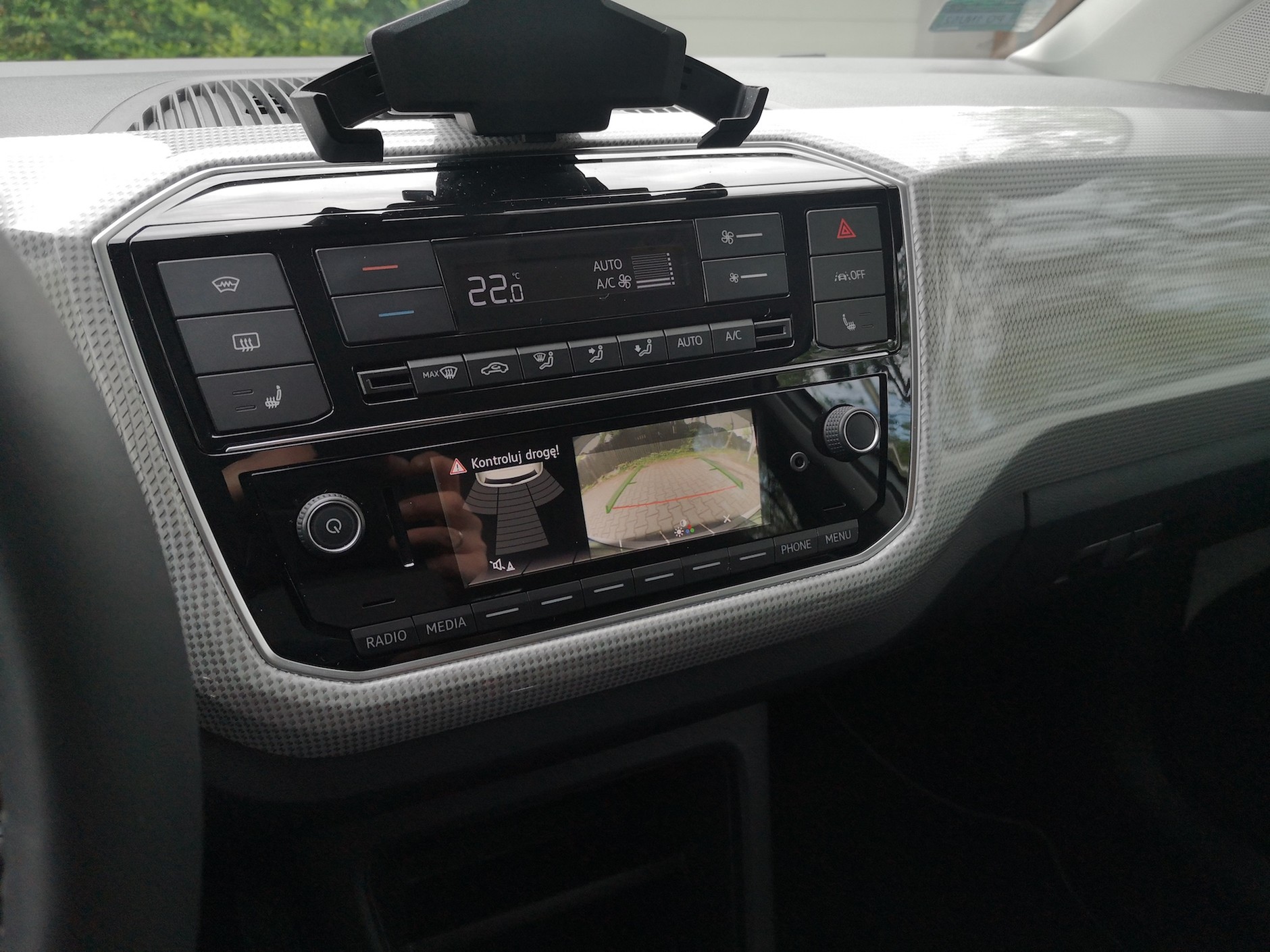 Volkswagen e-Up! Charakterystyczny, w gruncie rzeczy bardzo przydatny uchwyt na telefon; radio z wyświetlaczem podłączonym do kamery