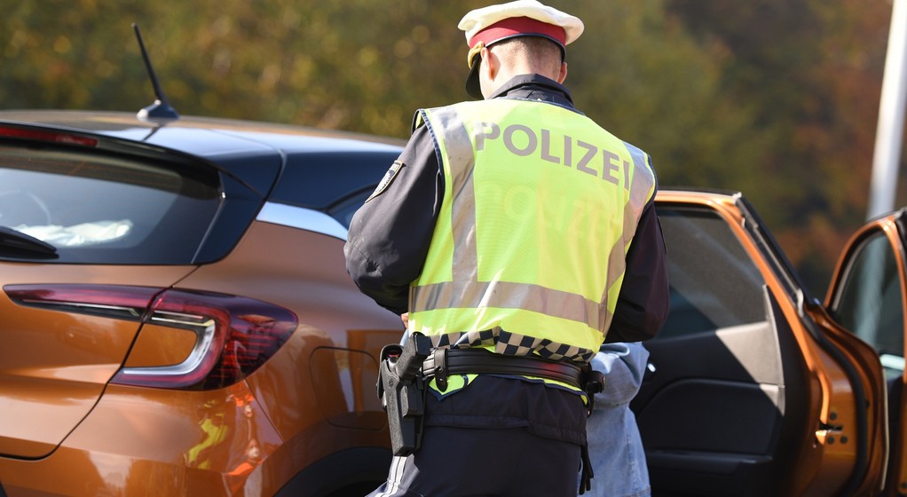 Austriacki policjant wypisujący mandat zatrzymanemu kierowcy