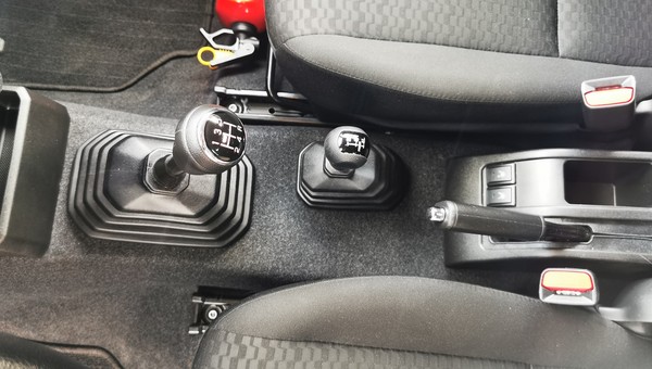 Drążek zmiany biegów i mniejsza dźwignia do sterowania napędem 4x4 i reduktorem