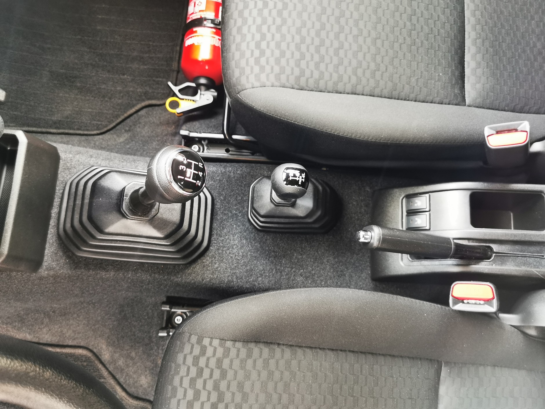 Drążek zmiany biegów i mniejsza dźwignia do sterowania napędem 4x4 i reduktorem