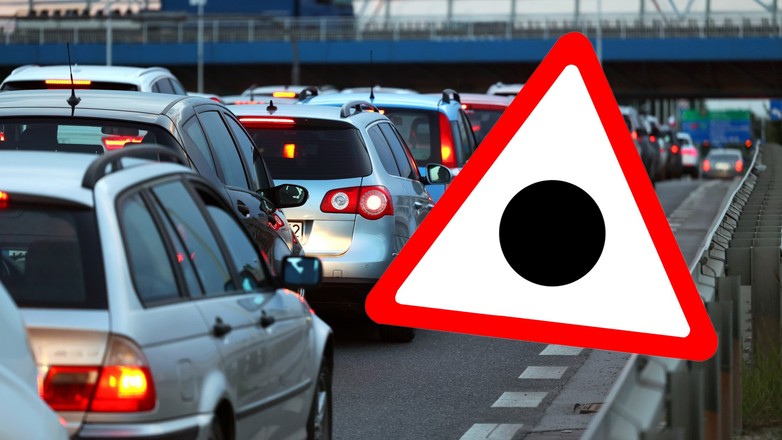 Znak drogowy przedstawiający czarną kropkę wpisaną w trójkąt ostrzegawczy