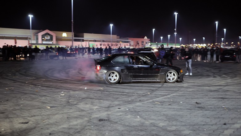 Nielegalny zlot samochodowy. Drift na parkingu pod supermarketem