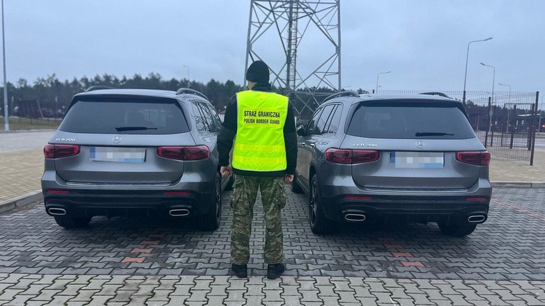 Funkcjonariusz SG stoi przy dwóch Mercedesach