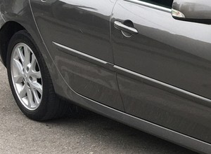 Renault Laguna z drzwiami, z których wylewa się woda [Nagranie]