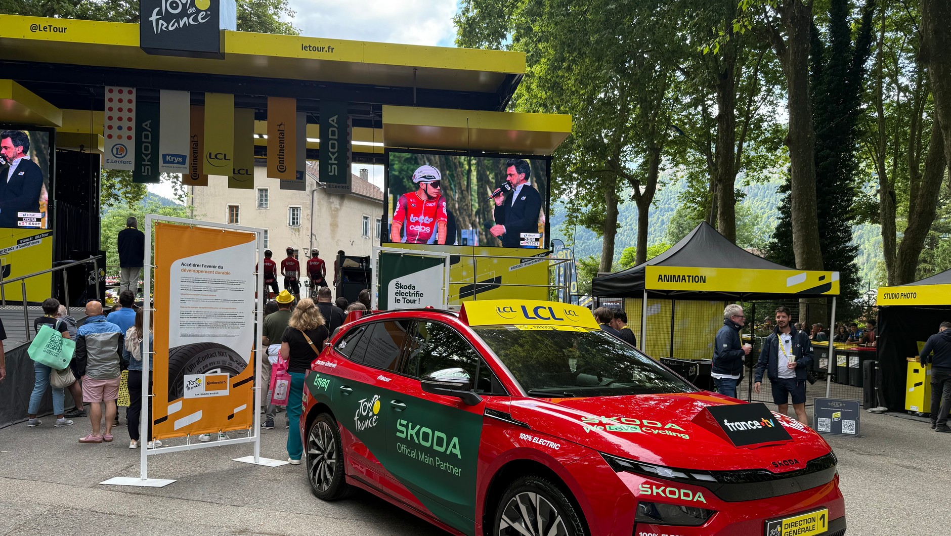 Przed startem 20 etapu TdF: na scenie widocznej od tyłu odbywa się prezentacja zawodników