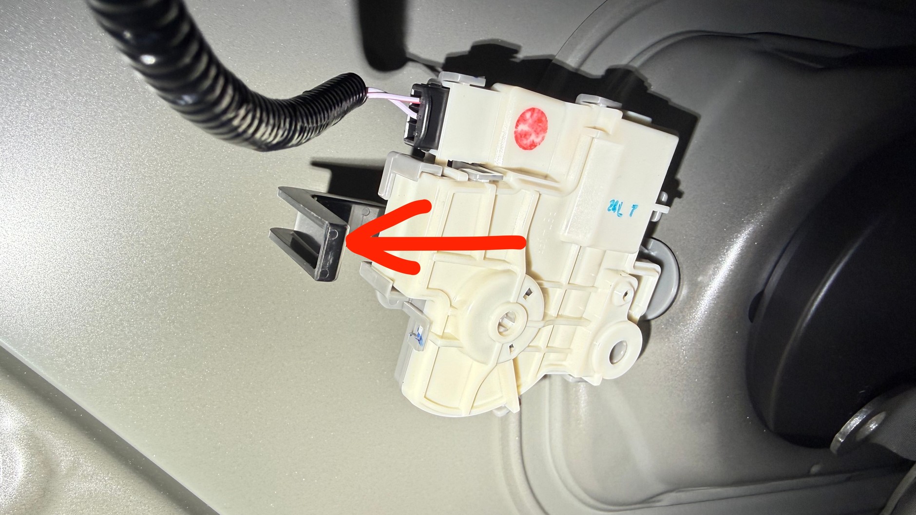 Zaglądamy przez otwór, a tam... w tym przypadku do awaryjnego otwarcia wlewu służy plastikowa dźwigienka na zamku elektrycznym, którą wystarczy pociągnąć