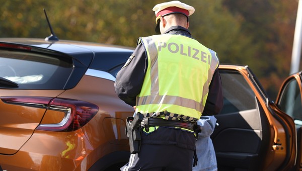 Austriacki policjant wypisujący mandat zatrzymanemu kierowcy