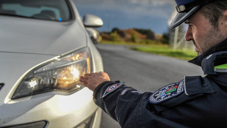 Policjant sprawdza światła podczas kontroli drogowej