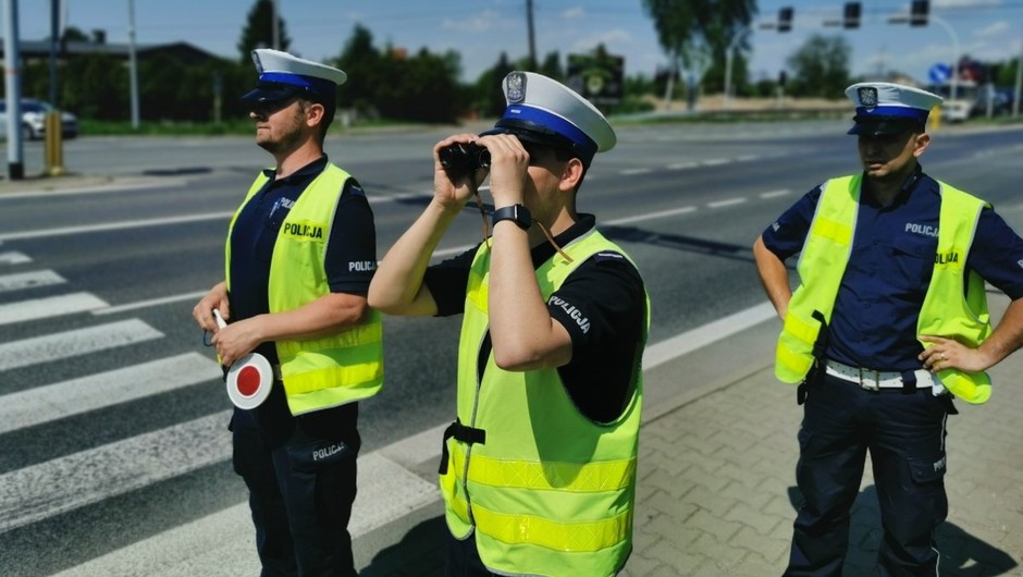 Policjanci korzystają z lornetek do typowania pojazdów do kontroli