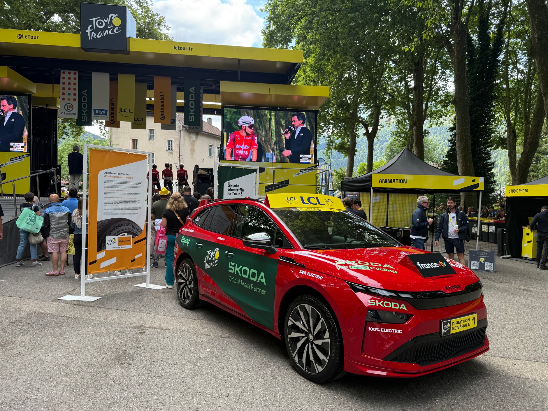 Przed startem 20 etapu TdF: na scenie widocznej od tyłu odbywa się prezentacja zawodników