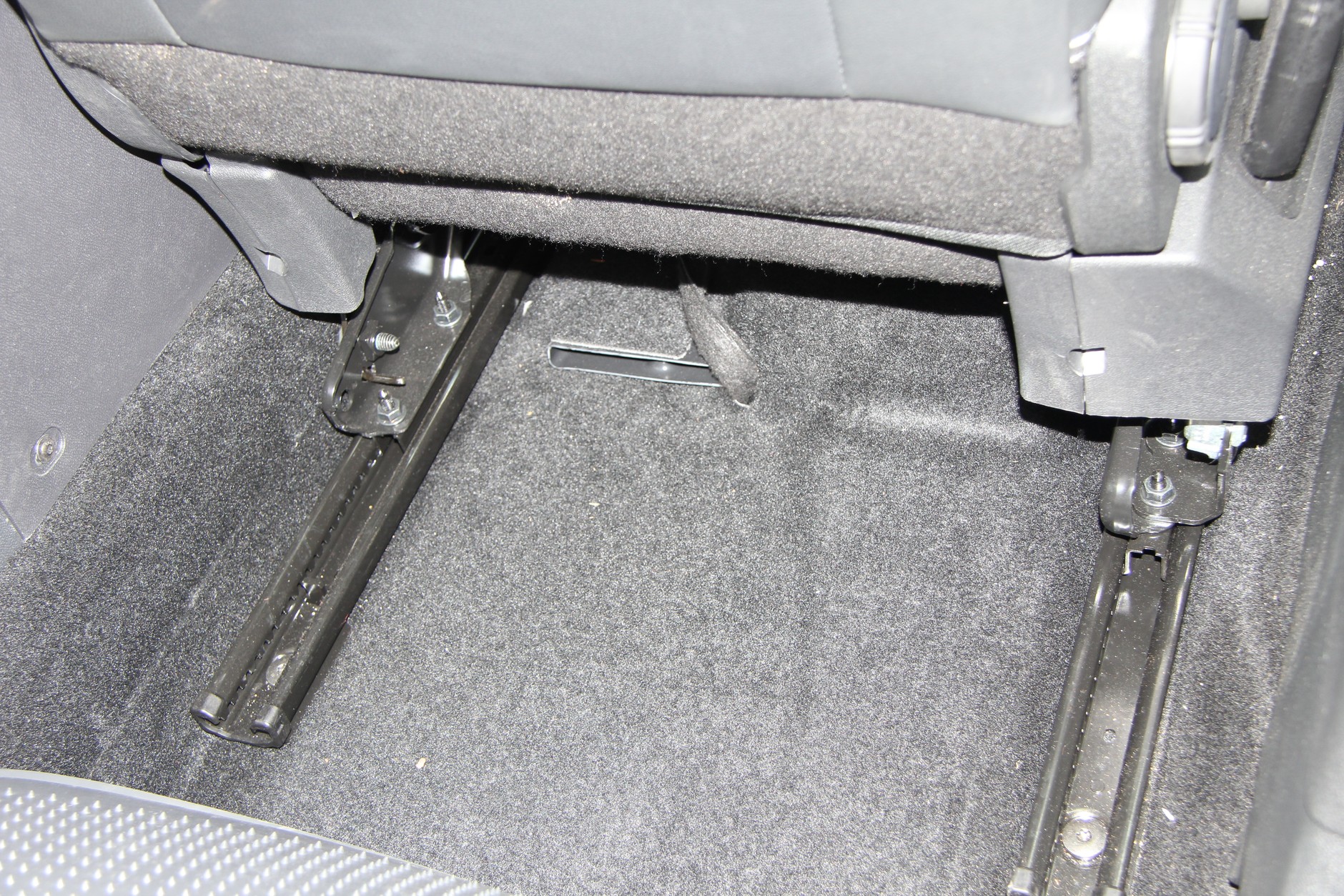 Subwoofer pod fotelem pasażera - schowany pod tapicerką. Widoczny fragment wiązki połączeniowej.