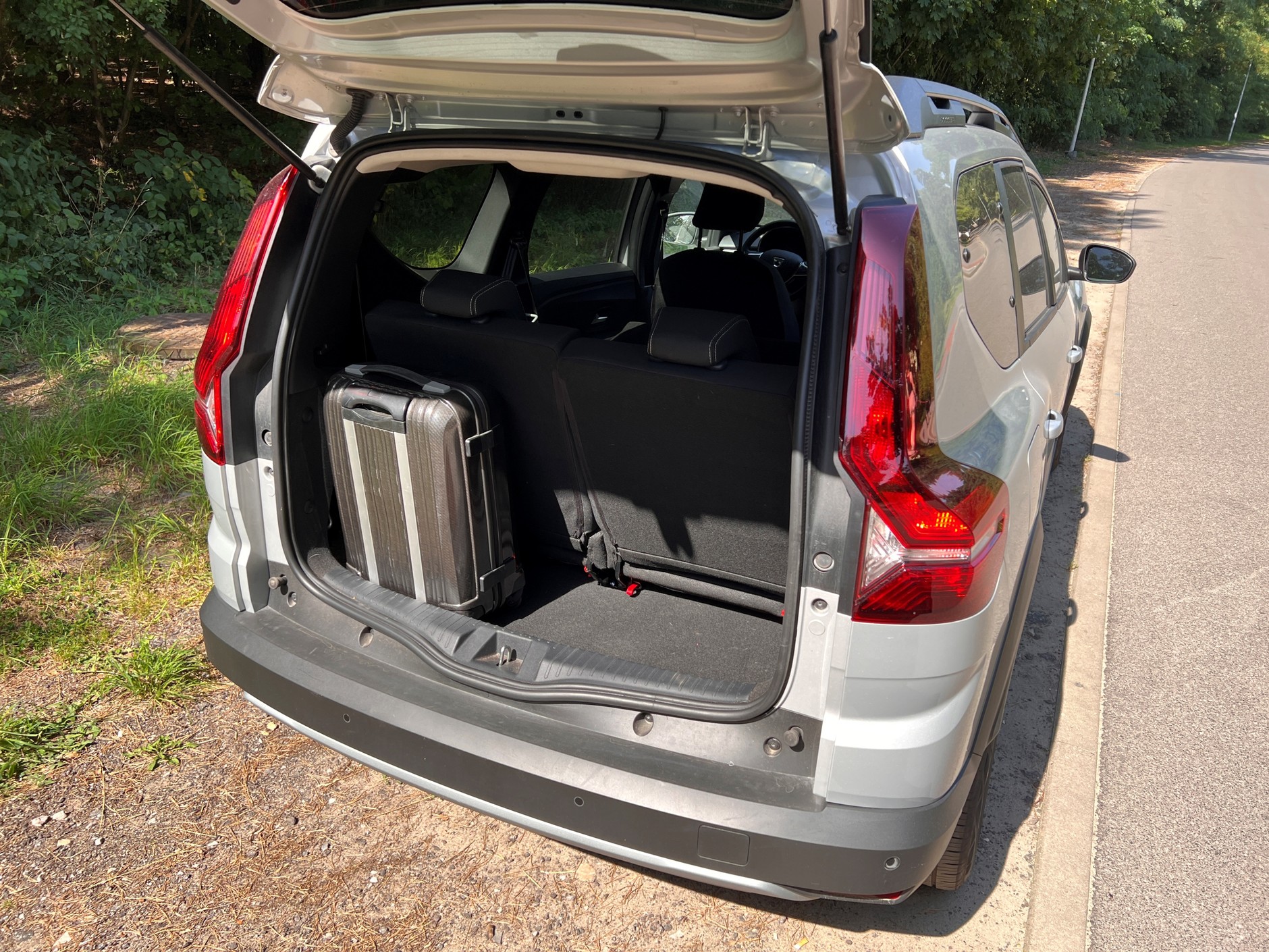 Nawet w 7-miejscowej konfiguracji w bagażniku Dacii Jogger bez problemu mieści się walizka kabinowa.