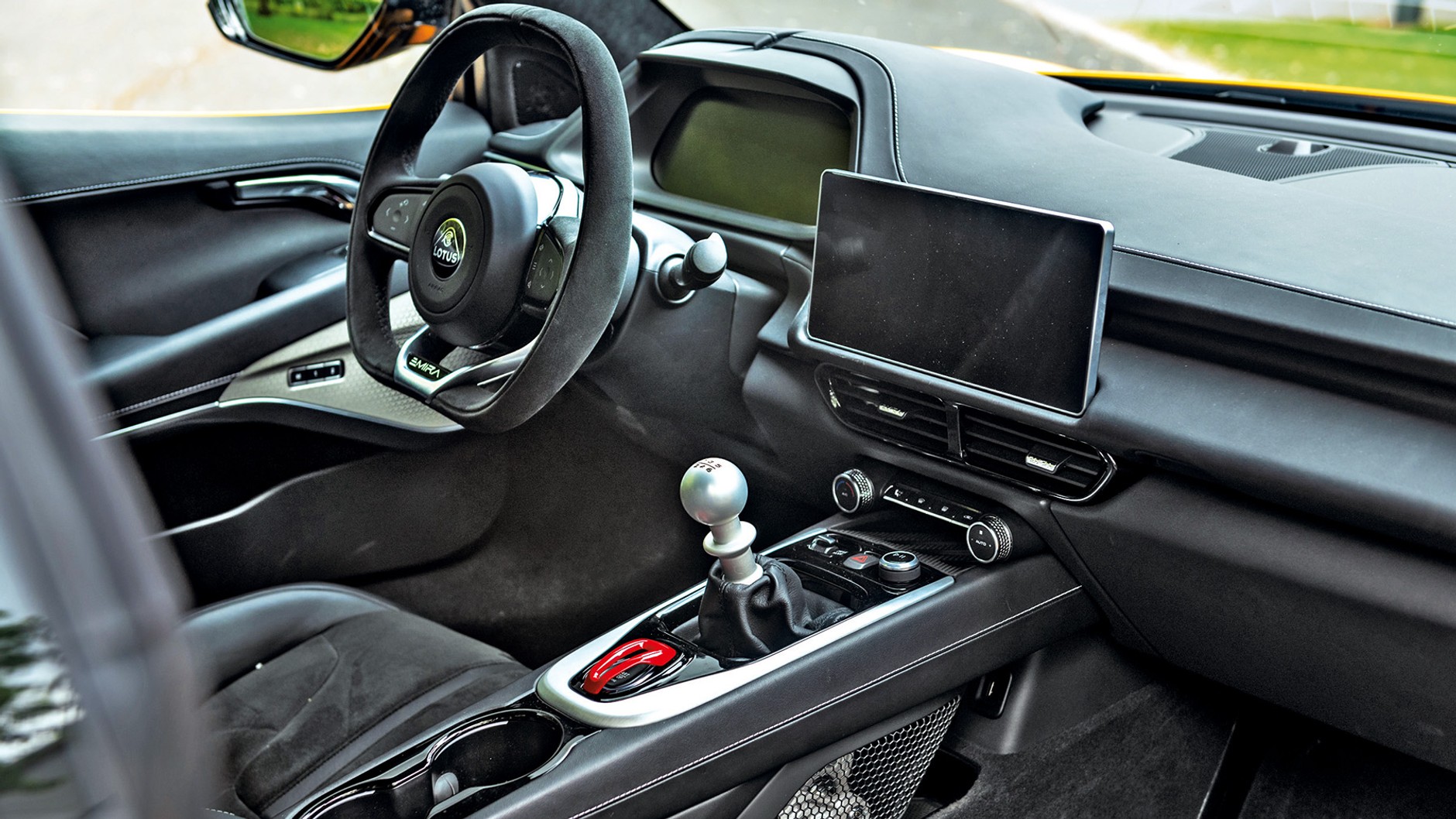Lotus podąża za nowoczesnością: kierowca Emiry patrzy na 12,3-calowy wyświetlacz cyfrowy
