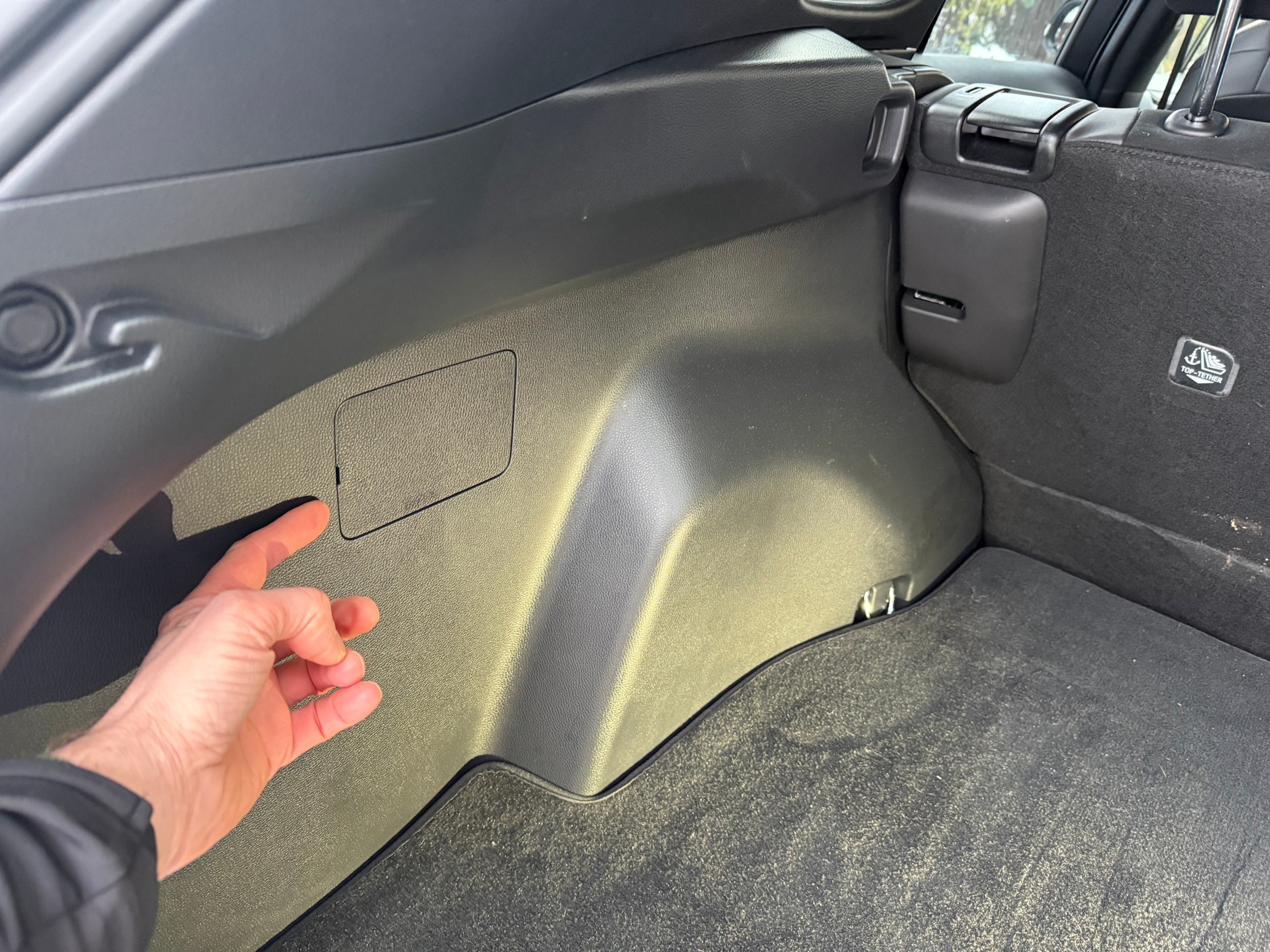 Szukasz awaryjnego systemu otwierania klapki wlewu paliwa? Tego rodzaju zaślepka w bagażniku a wysokości wlewu to bardzo czytelna sugestia: to tu