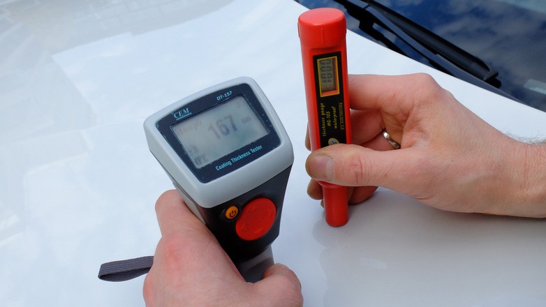 Dwa różne mierniki i... rzadko identyczny wynik!  w tym przypadku różnica wynika z faktu, iż maska samochodu wykonana jest z aluminium, a czerwony miernik na zdjęciu nie działa na aluminium i zwyczajnie „nie widzi” blachy.  Tanie mierniki w ogóle nie są idealnie dokładne