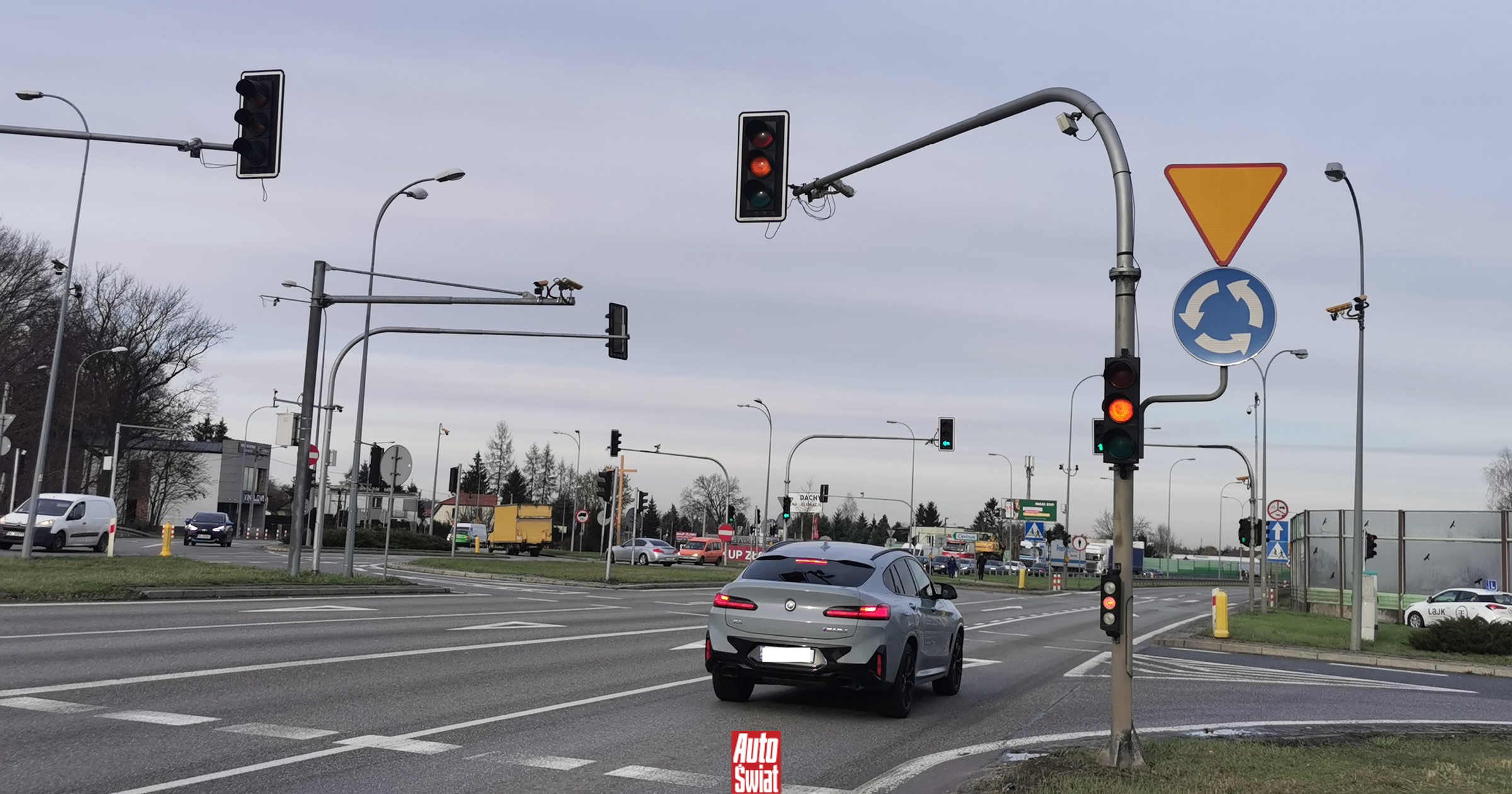 I conducenti si fermano davanti al skrzyżamento in Jabłonnie, aspettando la segnaletica stradale, con telecamere che monitorano i passaggi in rosso