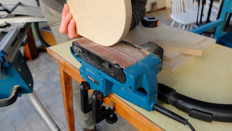 Ręczną szlifierkę taśmową można za pomocą zacisków umocować do stołu, zamieniając ją na urządzenie stacjonarne. Przy niektórych pracach jest to funkcja niezbędna
