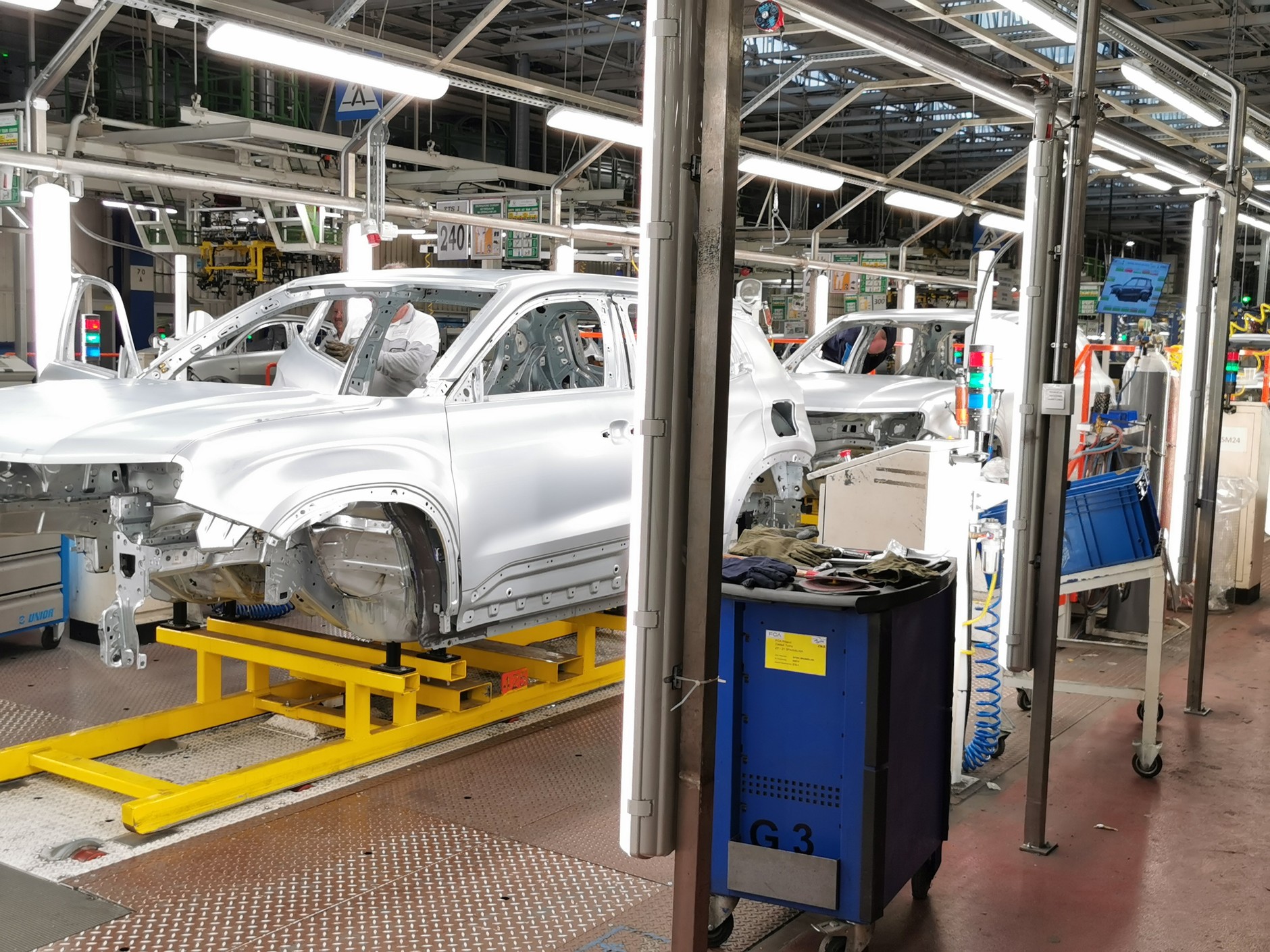 A to prawie gotowe już nadwozia na jednym z ostatnich etapów przed wysłaniem do lakierni: są drzwi, maska nie ma jeszcze klapki wlewu paliwa. Więcej światła i człowiek przy linii produkcyjnej to znak, że tu odbywa się ostatnia przed lakierowaniem kontrola jakości i kompletności karoserii.