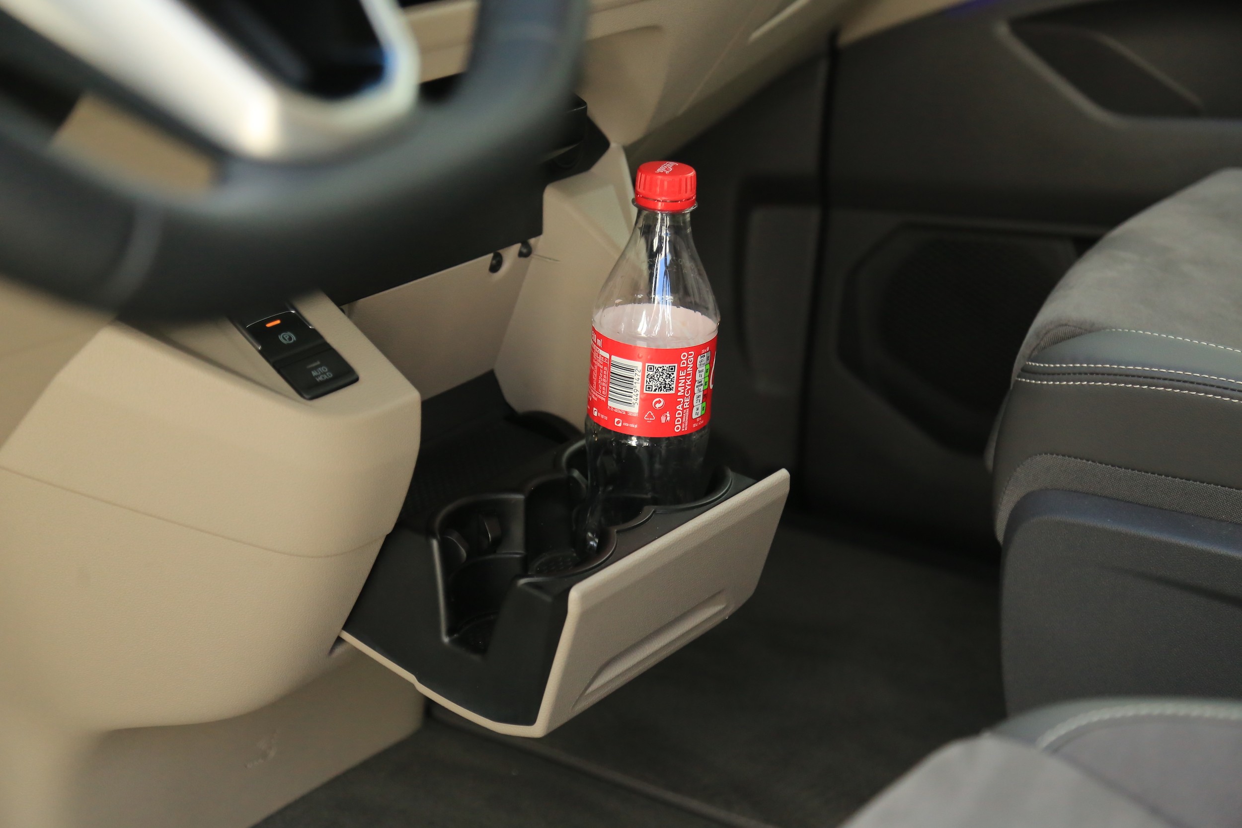 Wysuwany uchwyt na kubki w środkowej konsoli.