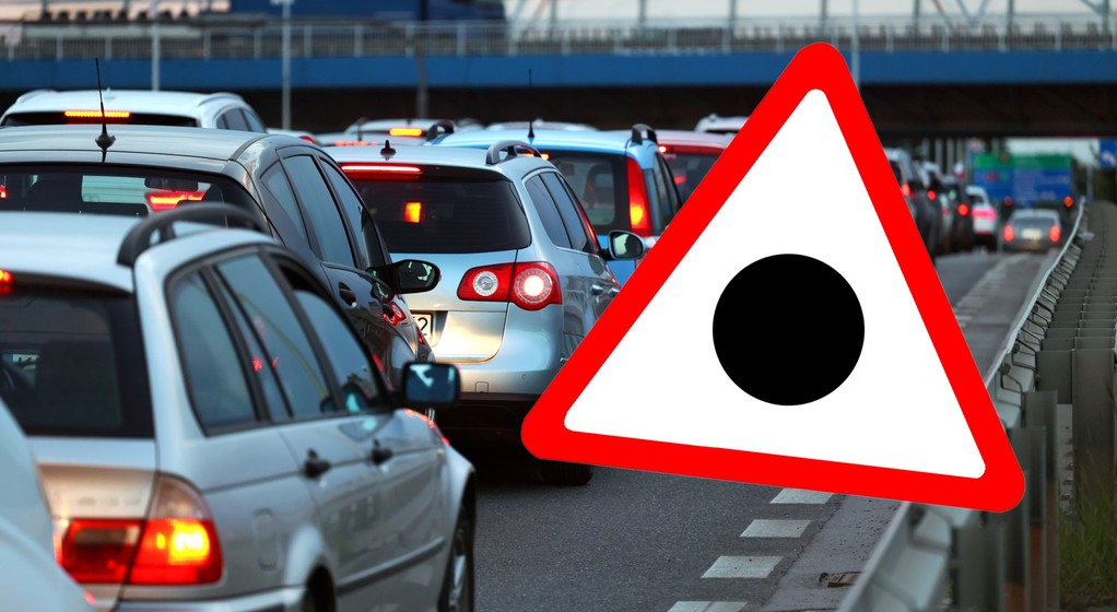 Znak drogowy przedstawiający czarną kropkę wpisaną w trójkąt ostrzegawczy