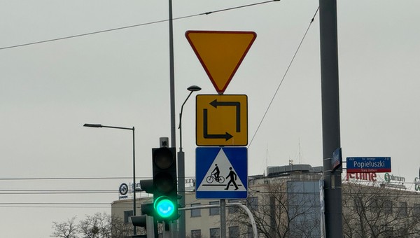 Znak drogowy informujący o bezkolizyjnym torze jazdy przy lewoskręcie