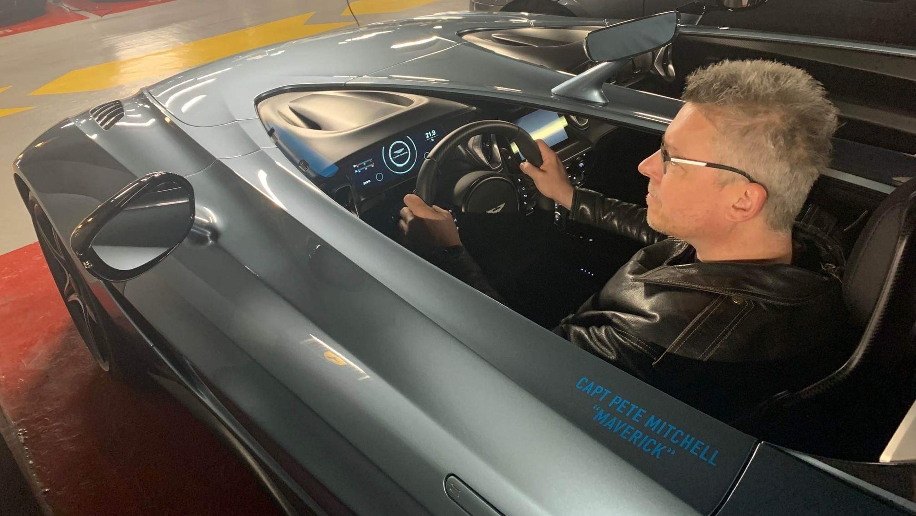Pisarz Rafał Kosik w Astonie Martinie V12 Speedster