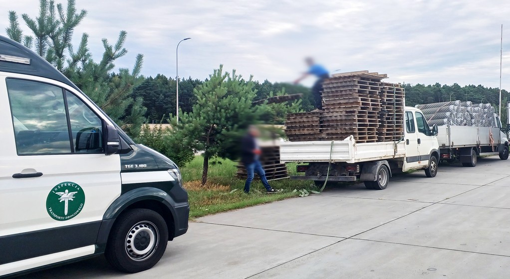 Kierowca rozładowuje puste palety, by móc pojechać dalej