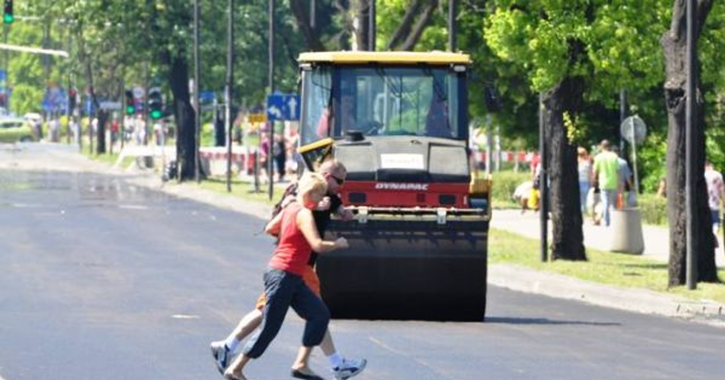 Piesi idą po gorący asfalcie