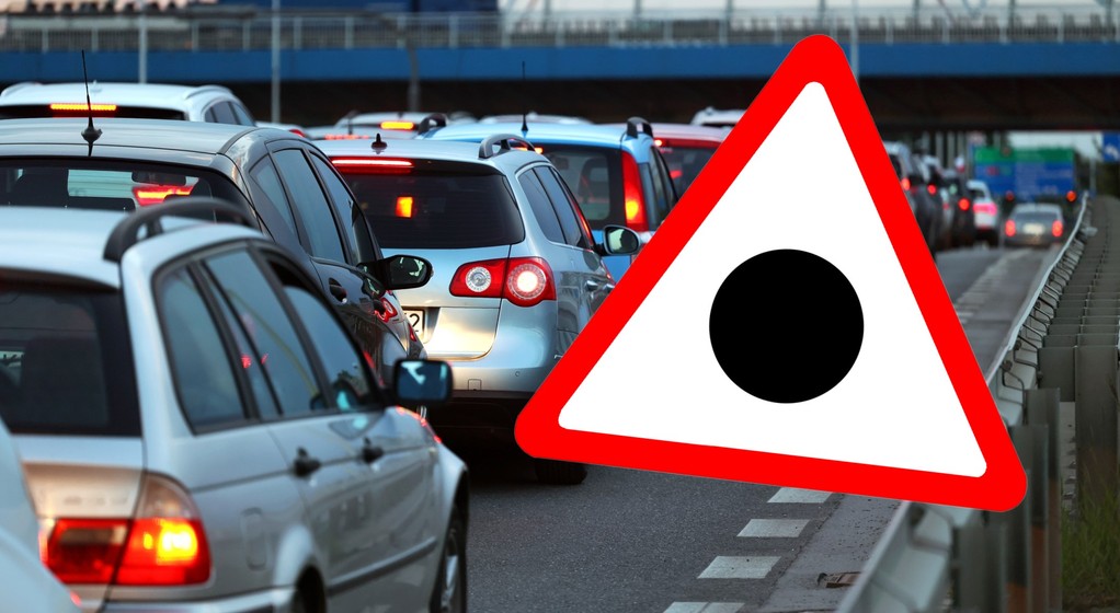 Znak drogowy przedstawiający czarną kropkę wpisaną w trójkąt ostrzegawczy