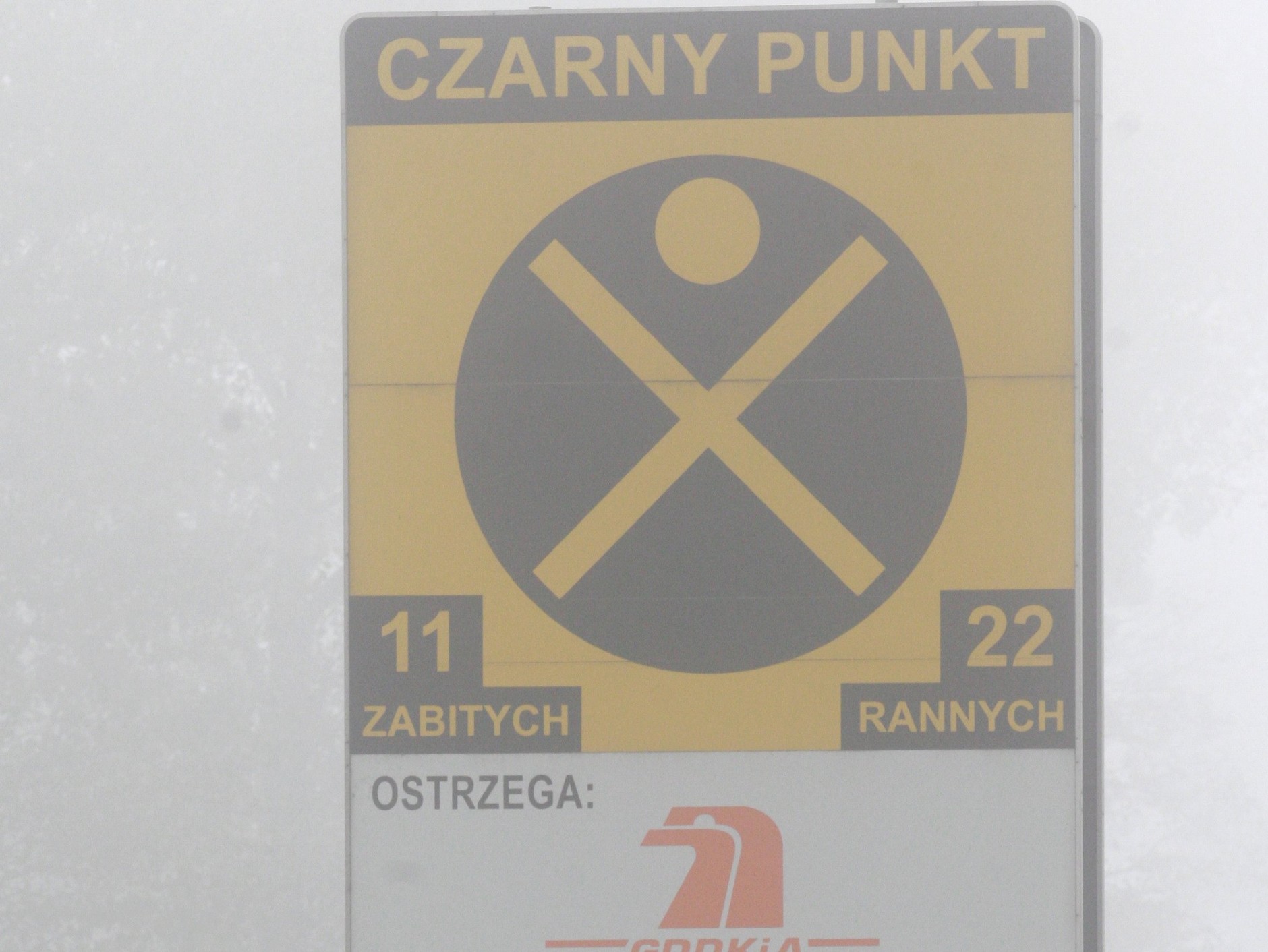 Zasłonięta przez mgłę polska tablica oznaczająca "czarny punkt"