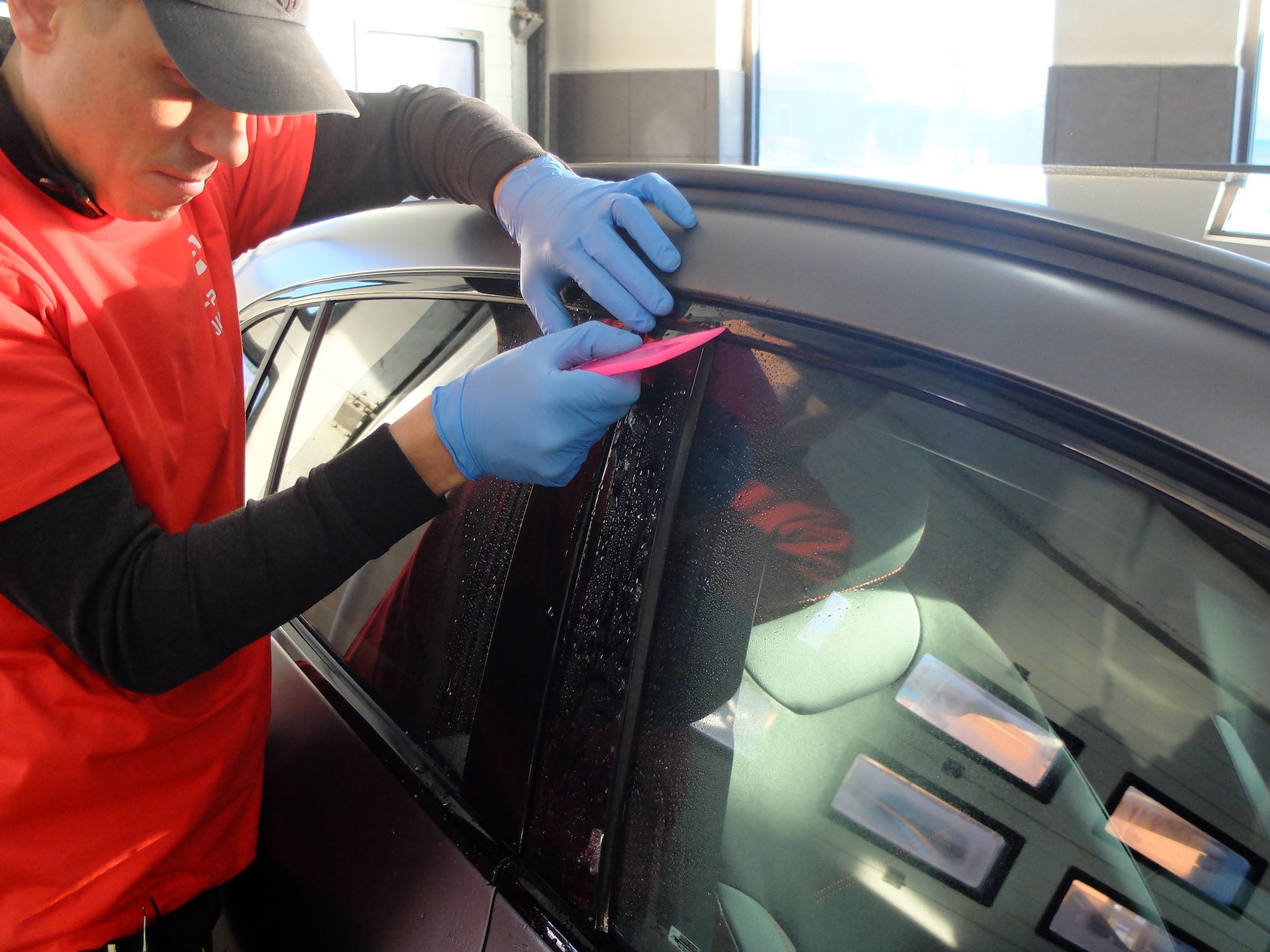 Folia PPF: folię nakleja się na mokro, a następnie za pomocą plastikowej szpachelki usuwa się spod niej wodę i powietrze