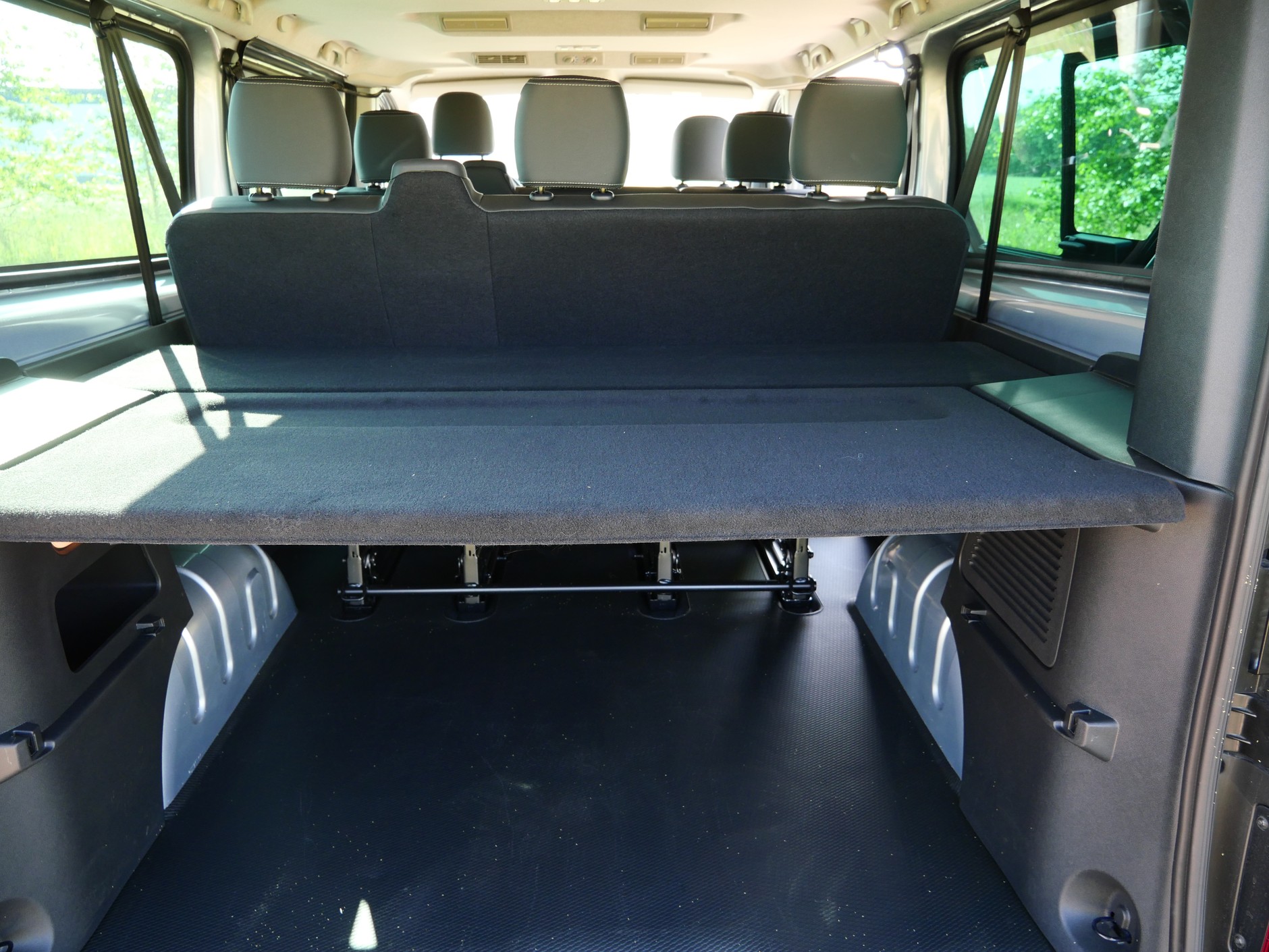 Nissan Primastar 2025: nawet przy komplecie foteli bagażnik pozostaje gigantyczny. To nie jest "salonka", we wnętrzu sporo gołej blachy. 