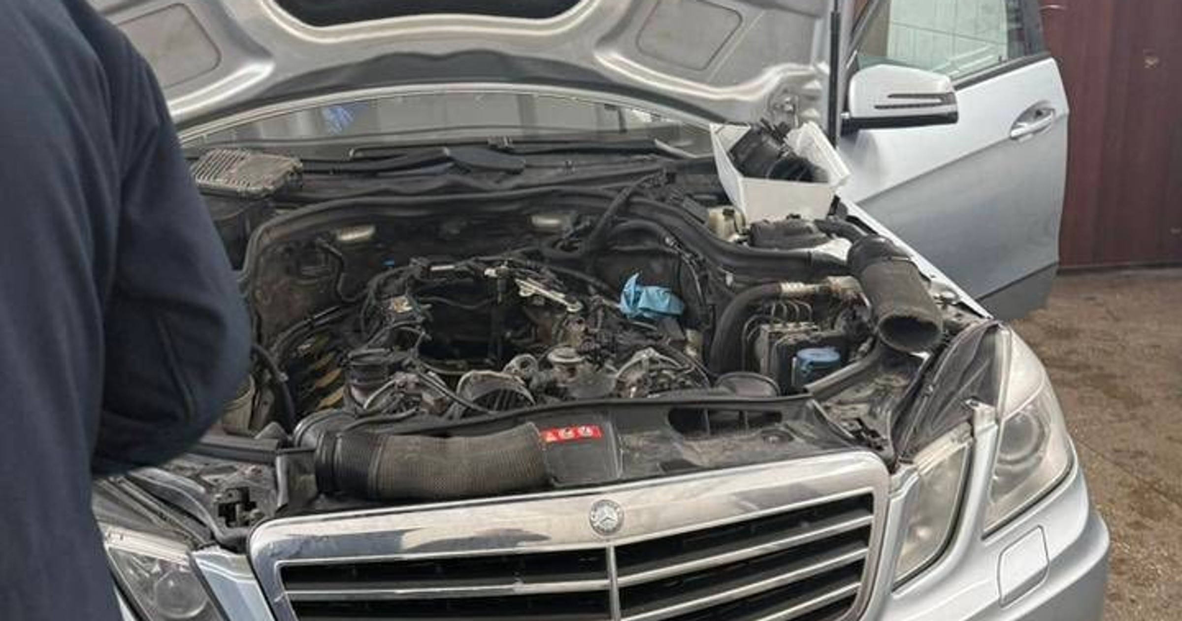 Pod maską Mercedesa W212 ktoś zbudował wymyślny schowek